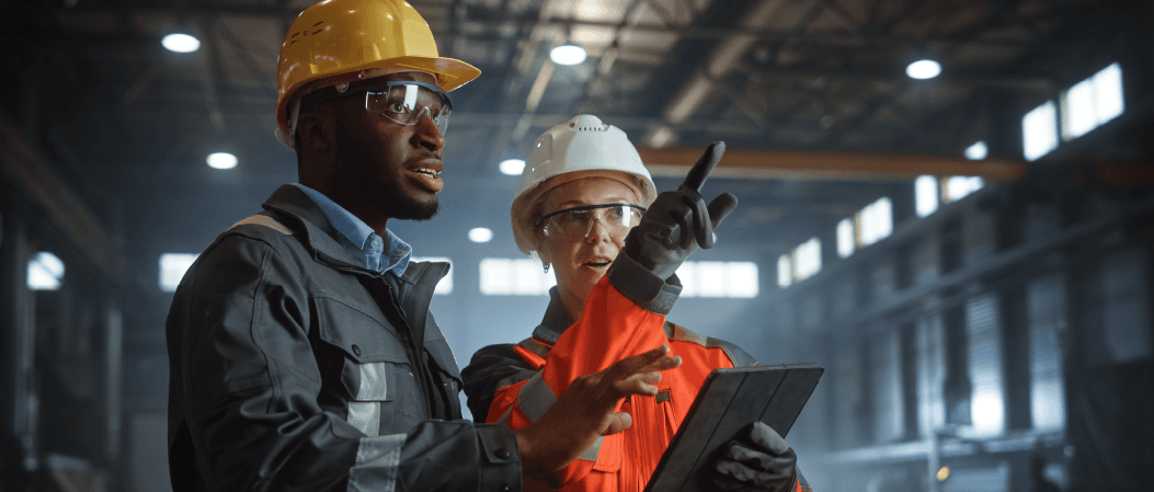 Manufacturing plant floor workers performing a safety inspection on a mobile tablet