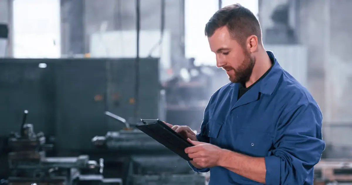 Manufacturing professional reviewing manufacturing scrap rates on a tablet in a production facility